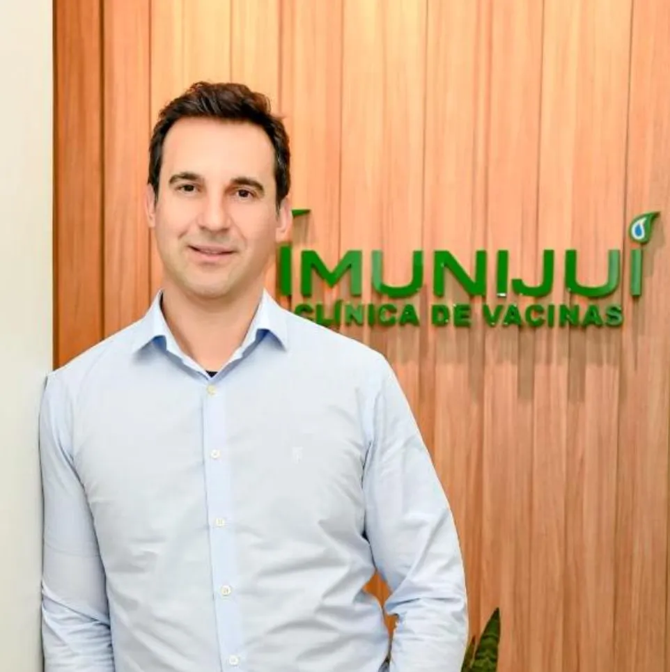 Márcio Rodrigues na frente da parede da Imunijuí, clínica de vacinas